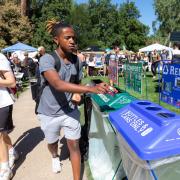 Man putting item in a recycling bin.