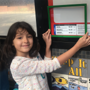 A Whittier Elementary School student uses a green frame to show that she likes the sign being low enough for children to read it. Students used green and red frames to frame the things they liked and didn’t like about the HOP.