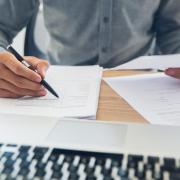 Person doing paperwork at a computer