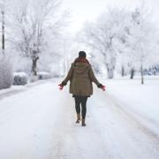 person walking down snowy street alone