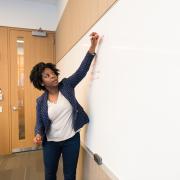 A woman writing on a dry erase board