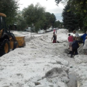 Plowing a large amount of hail in the street after a large hailstorm