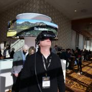 Lance Markowitz tries on virtual reality goggles at the CMCI booth at CU Boulder Next. Photo by Glenn Asakawa. 