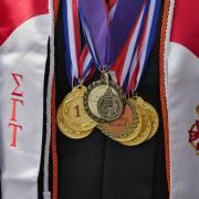 Graduate dons many medals during the commencement ceremony. Photo by Glenn Asakawa.