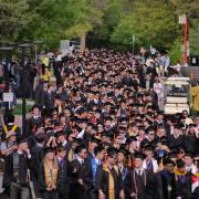 Graduates process to the main commencement ceremony at Folsom Field. Photo by Glenn Asakawa.