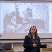 Graduate student Claire Steffen provides an overview to student social activism exhibit visitors. Photo by Glenn Asakawa.