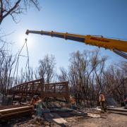 Workers use a mobile crane to place a 33-ton bridge over Boulder Creek on East Campus. Photo by Glenn Asakawa.