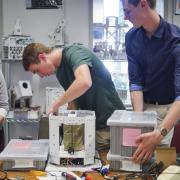 Anastasia Muszynski, Andrew Pfefer and Dawson Beatty work with their origami device