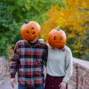 Two students wearing jack-o-lanterns on their heads