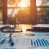 Financial documents, pen and reading glasses