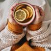 person drinking a cup of hot tea with lemon