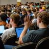 Student raising hand in lecture hall