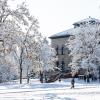 A snowy scene on the CU Boulder campus with snow-covered trees and grass.