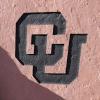 The letters "CU" in an interlocking design are etched in red stone.