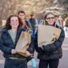 two students carrying paper bags on campus