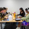 students chatting and studying at a table 