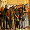 CAAAS Director Reiland Rabaka and seven other people surrounding him stand as a group in a hallway, posing for the camera with smiles.