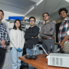 Researchers in a laboratory standing in front of computer.