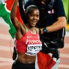 Faith Kipyegon running with a Kenyan flag