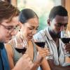 Three people sniff glasses of red wine