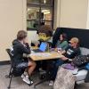 students sit with Chip the buffalo mascot at a libraries event