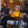 Chancellor Justin Schwartz looks at and listens to Peggy Coppom, both seated, during a living room chat. 