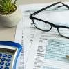tax documents, reading glasses, calculator and pen