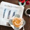 The New York Times paper on the table with a cup of coffee