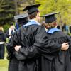 graduates standing arm in arm