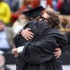 two graduates hugging after commencement ceremony