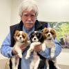 Kevin Fitzgerlad poses with puppies in his veterinarian office
