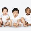 Five babies sitting on the floor