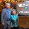 Terry and Charlotte Quarton in front of a 'Welcome to Colorful Colorado' sign