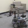 Robot on wheels in an office with a chair in the background
