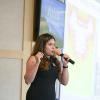 Woman speaking into microphone at a business pitch event