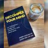 Decompile Your Mind book next to a cup of coffee