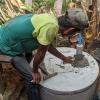 A man putting the finishing touches on an alternating dual-pit latrine in rural Cambodia