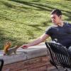 Senior Alex Elnagdy shares a peanut with a squirrel on campus. Photo by Glenn Asakawa.