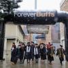 Graduates pose for photo under Forever Buffs blow-up arch