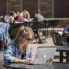 Student works on laptop in the UMC fountain area.