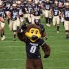Chip and the CU football team running onto the field
