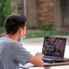 person on laptop on campus
