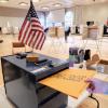 person drops ballot in a box