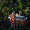 Old Main peeks through tree tops.