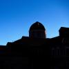Silhouette of a building on campus in front of a bluebird sky