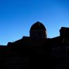 Silhouette of a building on campus in front of a bluebird sky