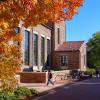 Autumn leaves frame a view of pedestrians and campus buildings.