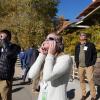 People wearing protective glasses look up at the sky