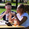 two campus community member sit at an outdoor table together