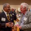 Awardee Olester Benson (left) converses with another person at the 2018 Alumni Awards ceremony.